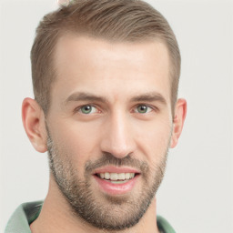 Joyful white young-adult male with short  brown hair and green eyes