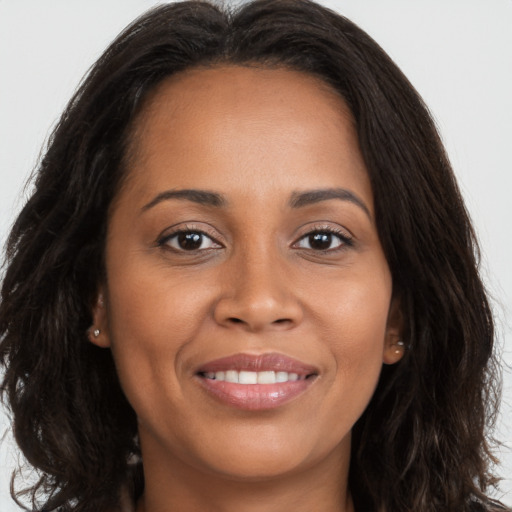 Joyful latino young-adult female with long  brown hair and brown eyes