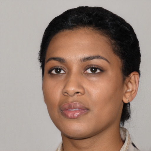 Joyful black young-adult female with short  black hair and brown eyes