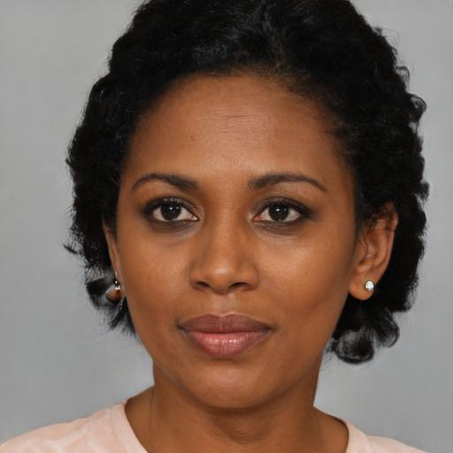 Joyful black young-adult female with medium  black hair and brown eyes