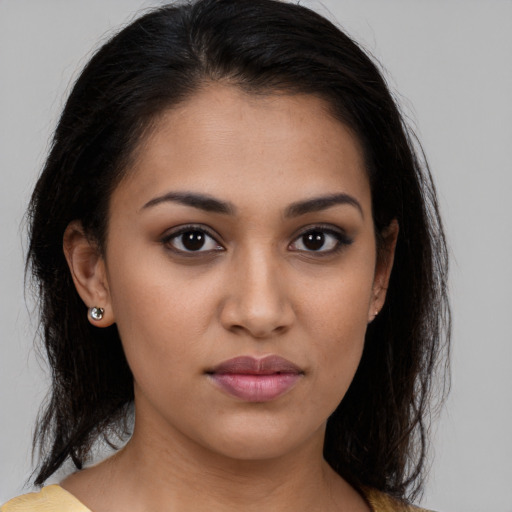 Joyful latino young-adult female with medium  brown hair and brown eyes