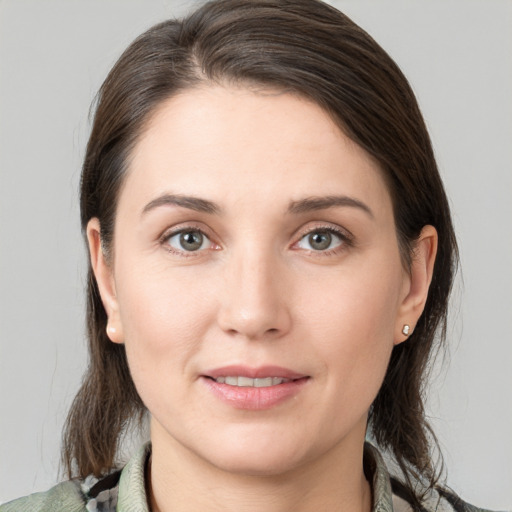 Joyful white young-adult female with medium  brown hair and grey eyes