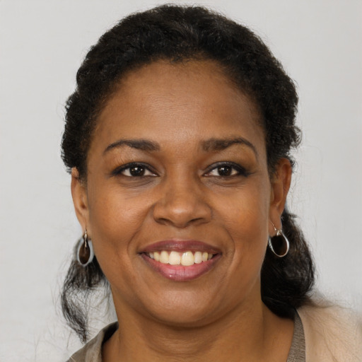 Joyful black adult female with long  brown hair and brown eyes