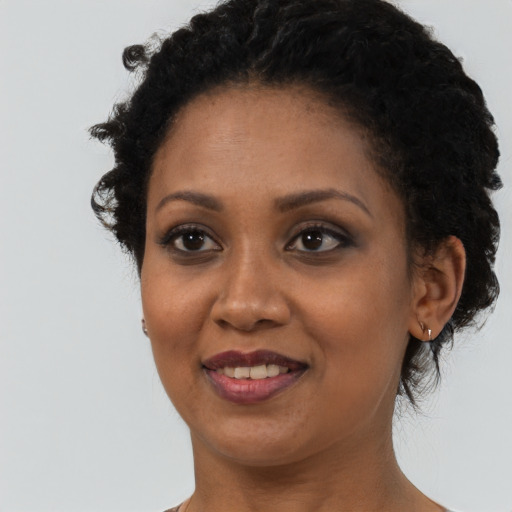Joyful black young-adult female with short  brown hair and brown eyes