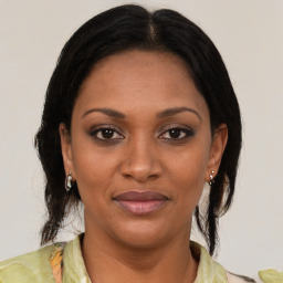 Joyful black adult female with medium  brown hair and brown eyes