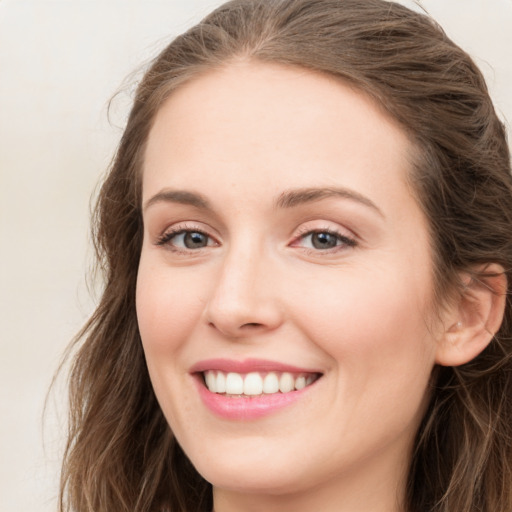 Joyful white young-adult female with long  brown hair and green eyes