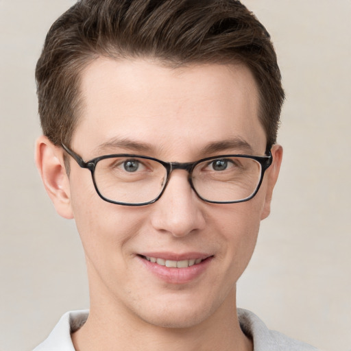 Joyful white young-adult male with short  brown hair and grey eyes