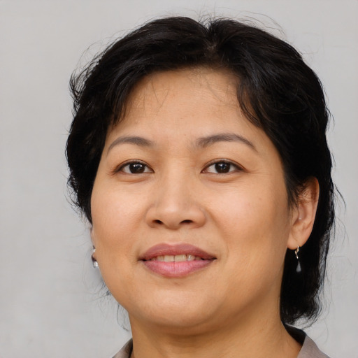 Joyful asian adult female with medium  brown hair and brown eyes