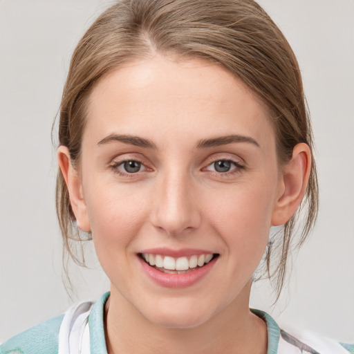 Joyful white young-adult female with medium  brown hair and blue eyes