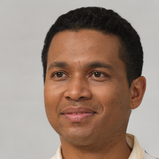 Joyful black young-adult male with short  black hair and brown eyes