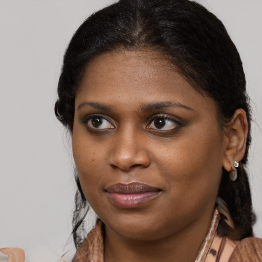 Joyful black young-adult female with medium  brown hair and brown eyes