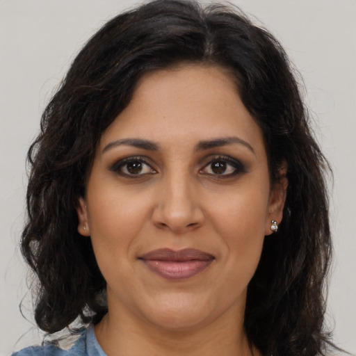 Joyful latino adult female with long  brown hair and brown eyes