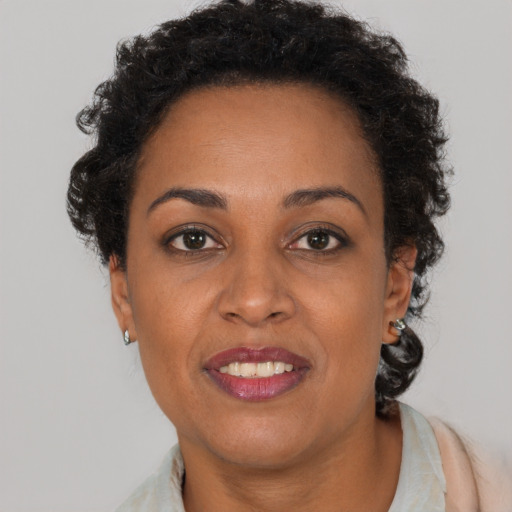 Joyful black adult female with short  brown hair and brown eyes