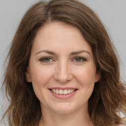 Joyful white adult female with long  brown hair and brown eyes