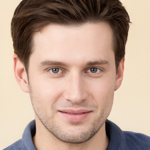 Joyful white young-adult male with short  brown hair and grey eyes