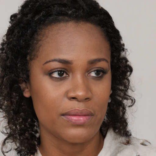 Neutral black young-adult female with medium  brown hair and brown eyes