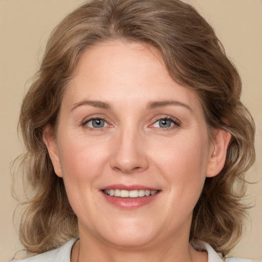 Joyful white adult female with medium  brown hair and green eyes