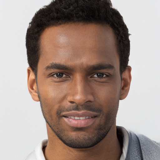 Joyful black young-adult male with short  brown hair and brown eyes