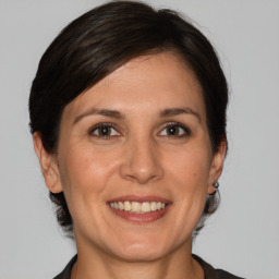 Joyful white adult female with medium  brown hair and grey eyes