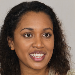 Joyful black young-adult female with long  brown hair and brown eyes