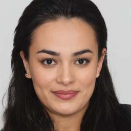 Joyful latino young-adult female with long  brown hair and brown eyes