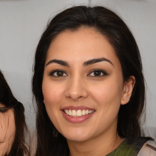 Joyful white young-adult female with long  brown hair and brown eyes