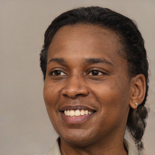 Joyful black young-adult female with short  black hair and brown eyes