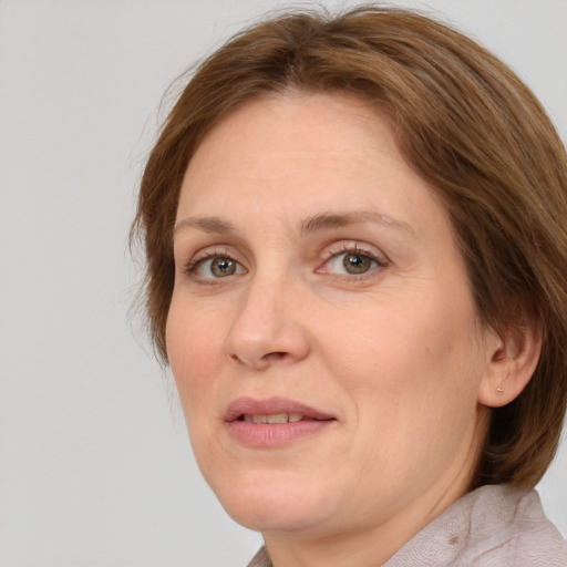 Joyful white adult female with medium  brown hair and green eyes