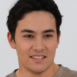 Joyful latino young-adult male with short  brown hair and brown eyes