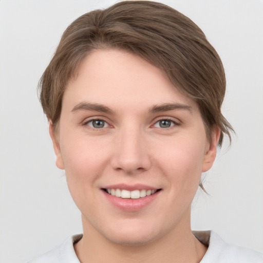 Joyful white young-adult female with short  brown hair and grey eyes