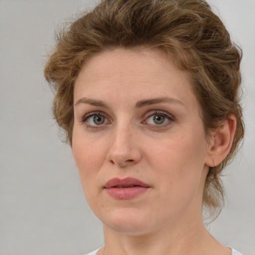 Joyful white young-adult female with medium  brown hair and green eyes