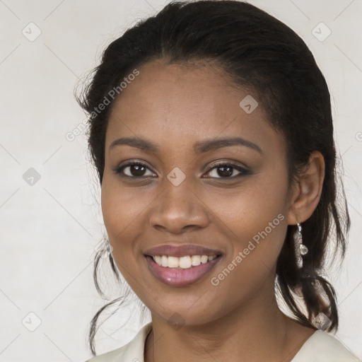 Joyful black young-adult female with long  brown hair and brown eyes