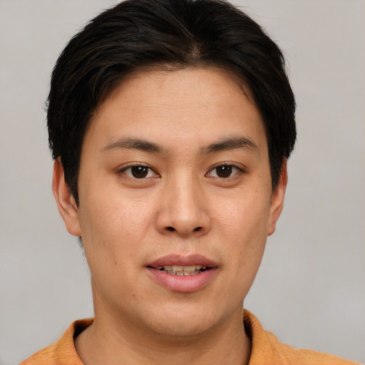 Joyful asian young-adult male with short  brown hair and brown eyes