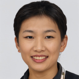 Joyful asian young-adult female with short  brown hair and brown eyes