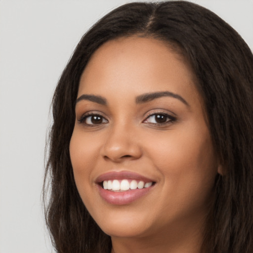 Joyful latino young-adult female with long  brown hair and brown eyes