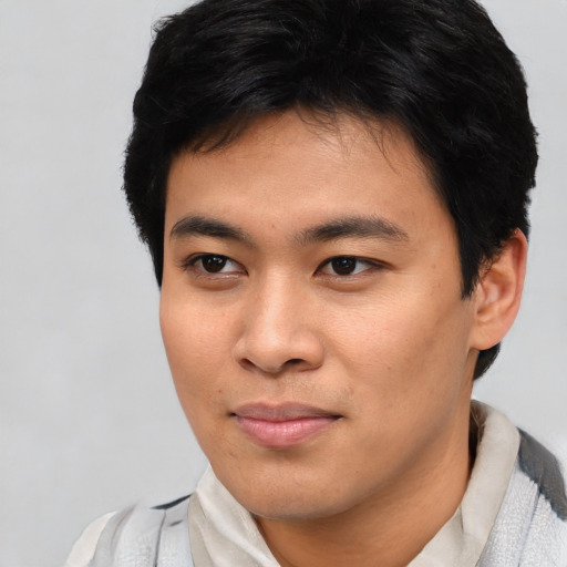 Joyful asian young-adult male with short  brown hair and brown eyes