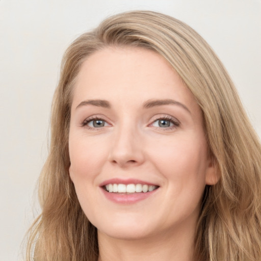 Joyful white young-adult female with long  brown hair and blue eyes