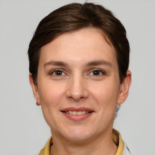 Joyful white young-adult female with short  brown hair and grey eyes