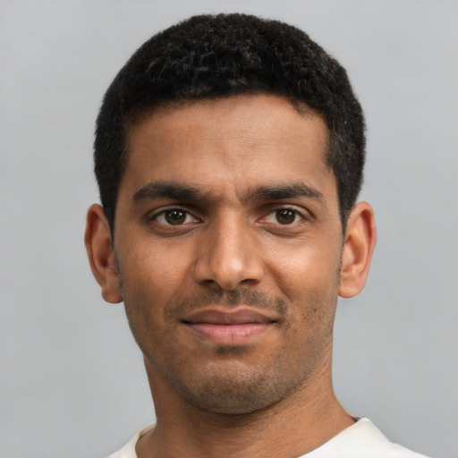 Joyful black young-adult male with short  black hair and brown eyes