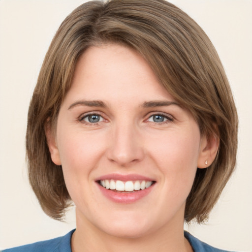 Joyful white young-adult female with medium  brown hair and green eyes