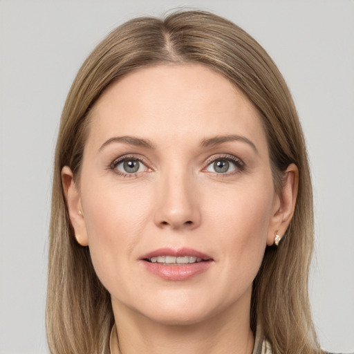 Joyful white adult female with long  brown hair and grey eyes