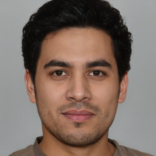 Joyful latino young-adult male with short  brown hair and brown eyes