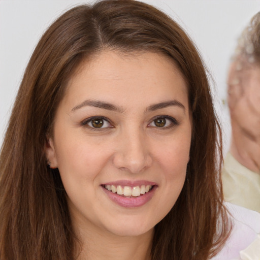 Joyful white young-adult female with long  brown hair and brown eyes