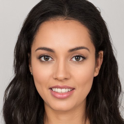 Joyful latino young-adult female with long  brown hair and brown eyes