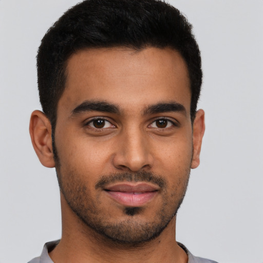 Joyful latino young-adult male with short  brown hair and brown eyes
