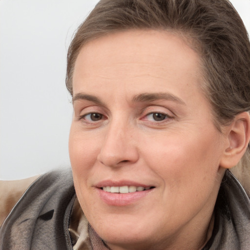 Joyful white adult female with long  brown hair and grey eyes