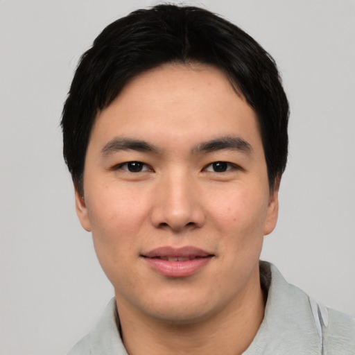 Joyful asian young-adult male with short  black hair and brown eyes