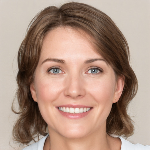 Joyful white young-adult female with medium  brown hair and blue eyes