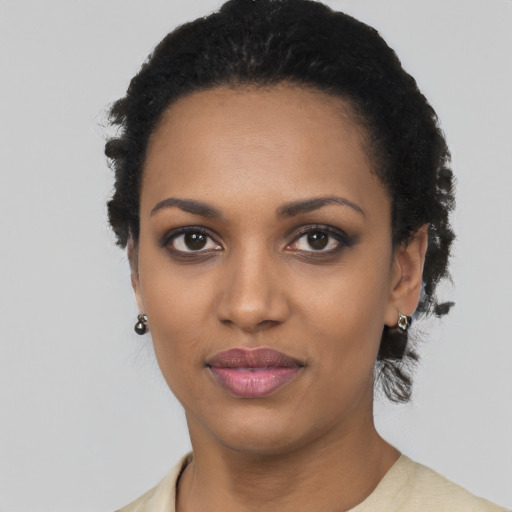 Joyful black young-adult female with short  black hair and brown eyes