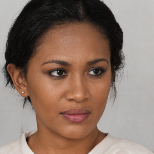 Joyful black young-adult female with medium  brown hair and brown eyes